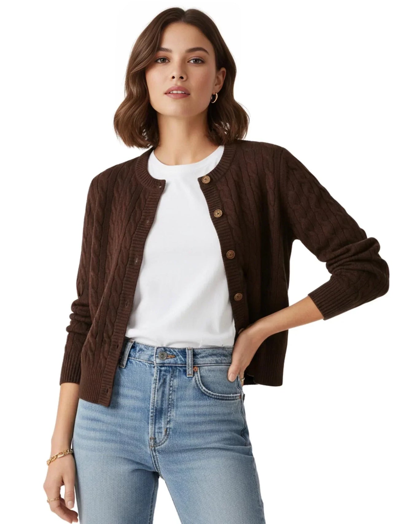 Woman wearing a brown cable knit cardigan over a white shirt and blue jeans on a white background