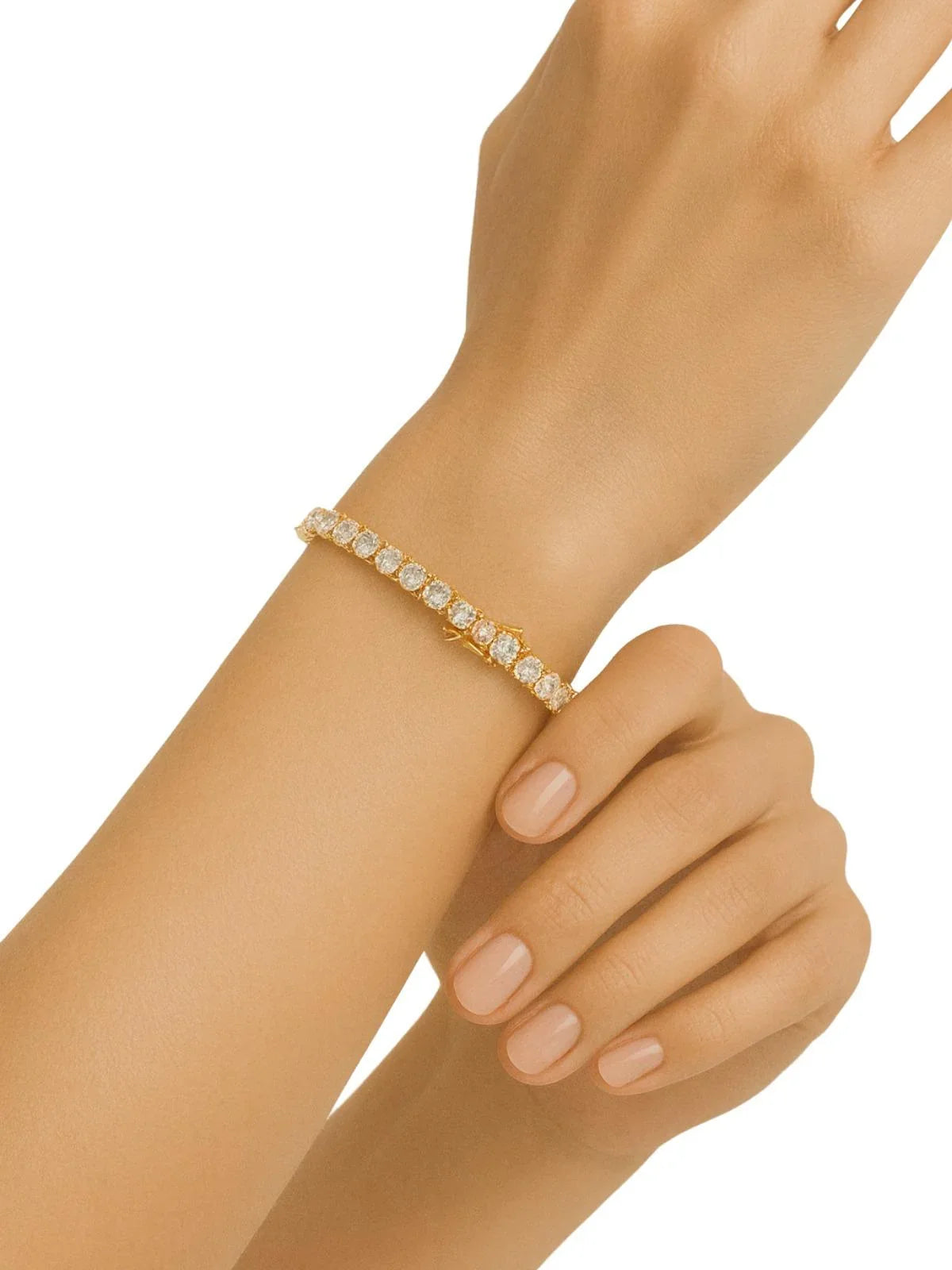 Gold diamond tennis bracelet on a wrist with a plain background