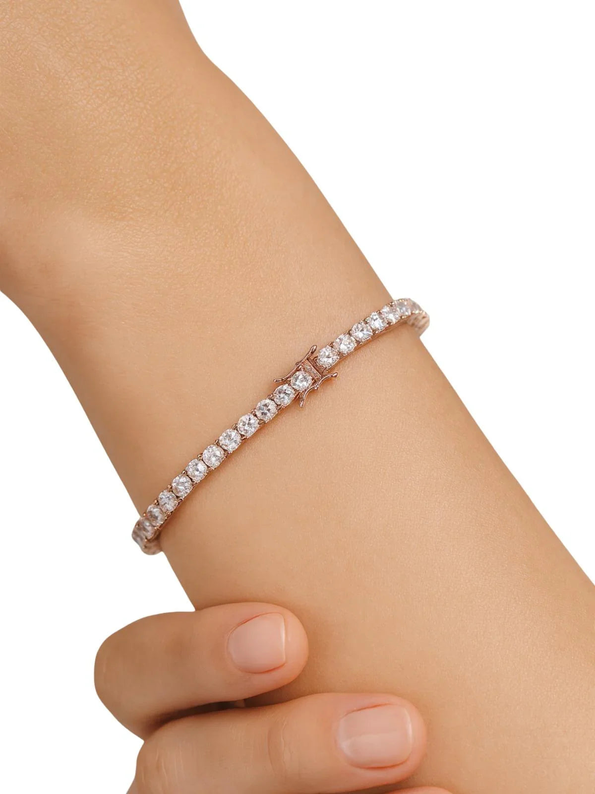 Rose gold diamond tennis bracelet on a wrist against a white background