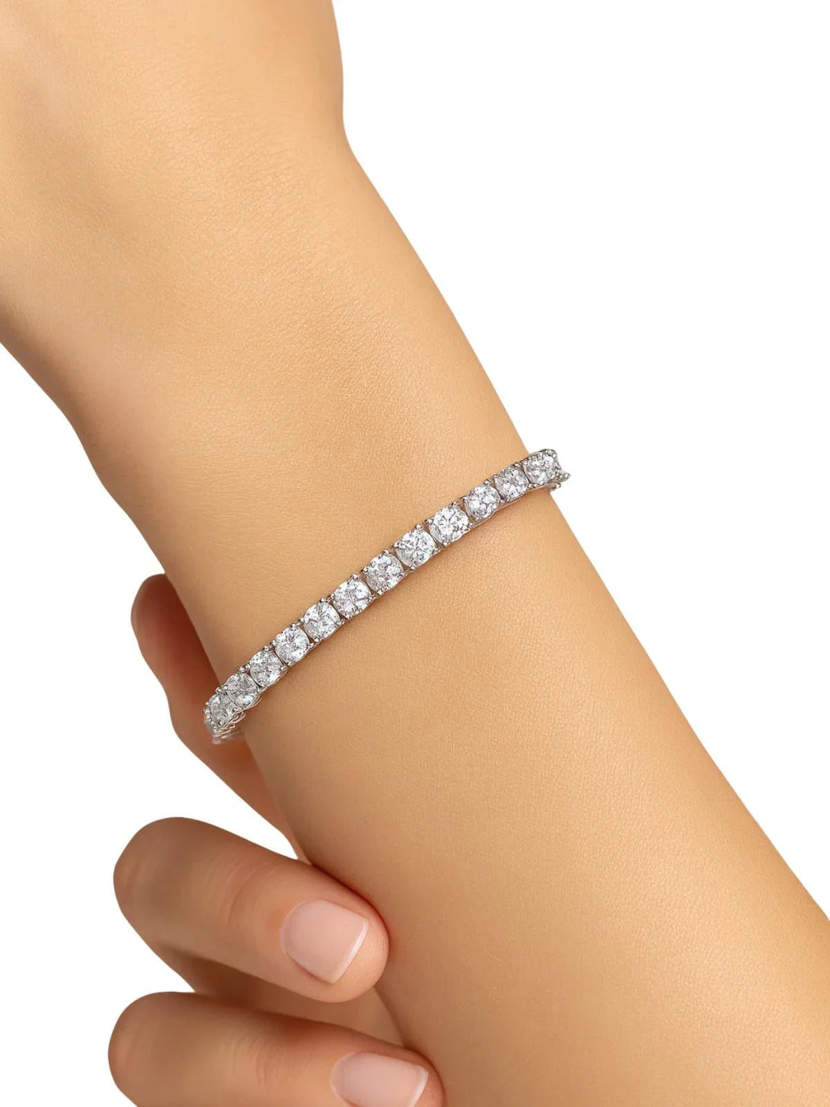 Diamond tennis bracelet on a person's wrist against a white background