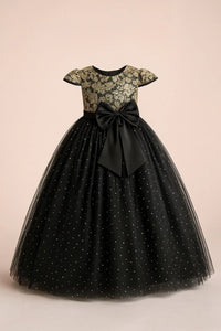 Thumbnail for Black dress with gold lace top and bow on a beige background