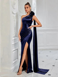 Thumbnail for Woman wearing a navy blue satin one-shoulder gown with a high slit in a white room.