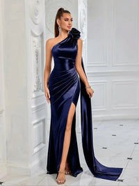 Thumbnail for Woman wearing a navy blue satin one-shoulder gown with a high slit in a white room.