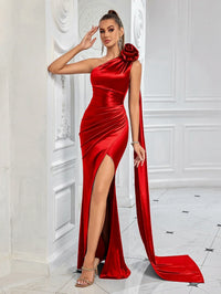 Thumbnail for Woman wearing a red satin one shoulder gown with a high slit in a white room.
