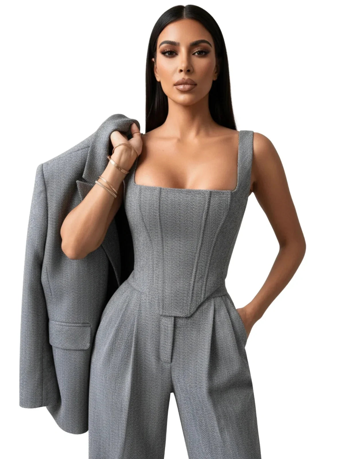 Woman wearing a gray suit holding a matching blazer on a white background