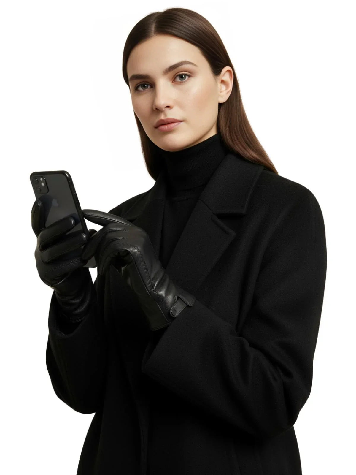 Woman in a black coat and black leather touch screen gloves holding a phone on a white background
