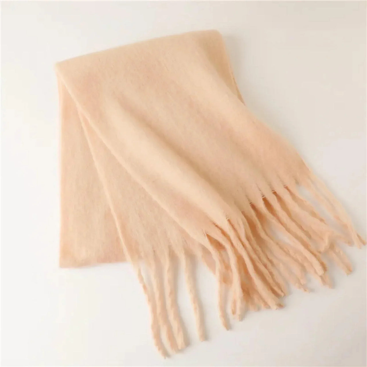 Blush scarf with tassels on a light gray background