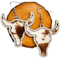 Thumbnail for Cow-shaped earrings with rhinestone accents on a wooden block