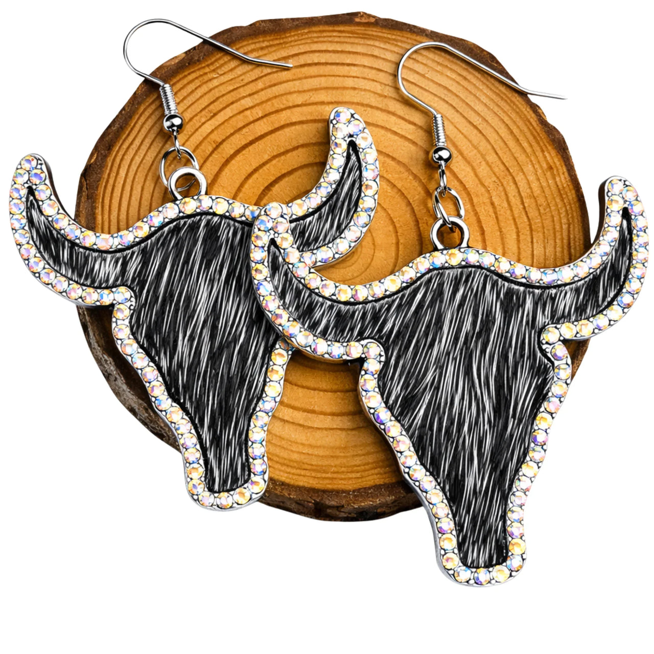 Bull head-shaped earrings with rhinestones on a wooden background