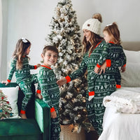 Thumbnail for Family in matching green Christmas pajamas standing around a decorated Christmas tree.