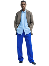 Thumbnail for Man wearing a light blue shirt, brown jacket, and royal blue pants on a white background