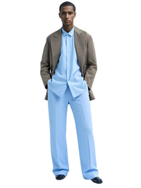 Thumbnail for Man wearing a light blue shirt and light blue pants with a brown jacket on a white background