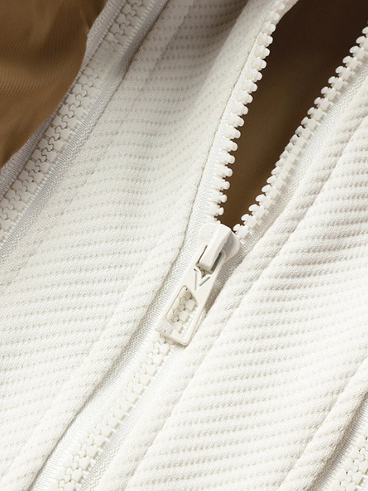 Close-up of a white zipper on a textured fabric background