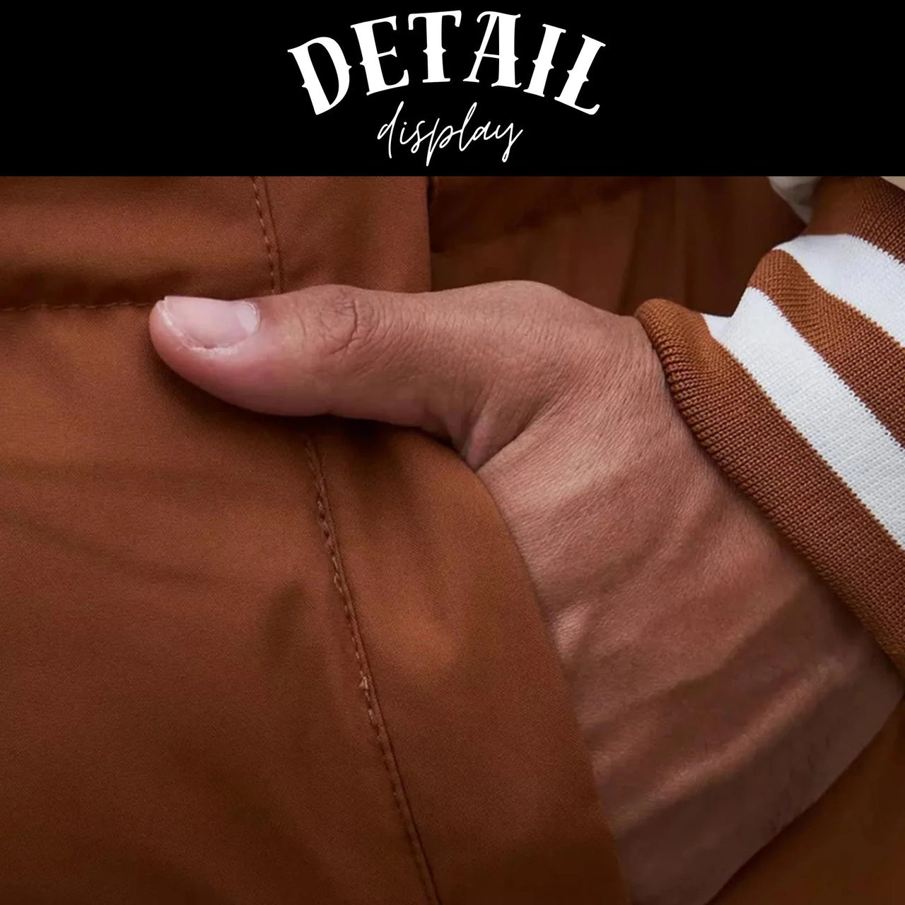Close-up of a hand wearing a brown jacket with a visible brand name.
