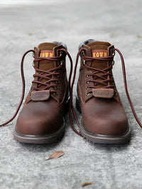 Thumbnail for Pair of brown leather boots with laces on a gray surface
