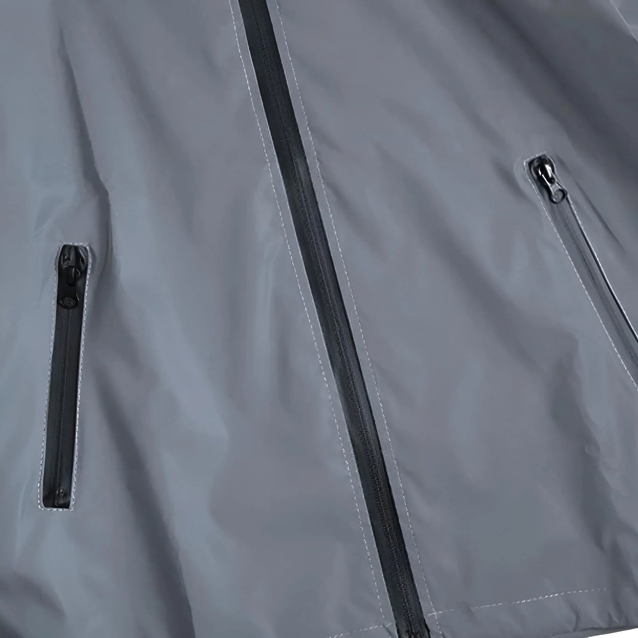 Close-up of a gray reflective jacket with zippers on a dark background
