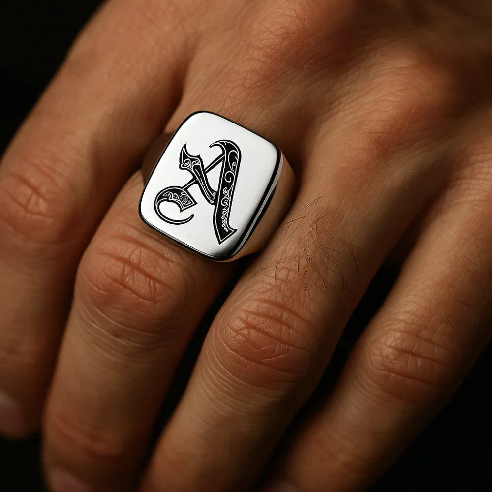 Silver ring with the initial 'a' on a hand