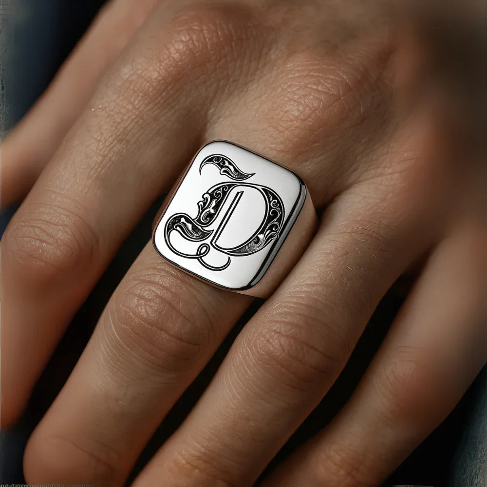 Silver ring with the initial 'd' on a hand