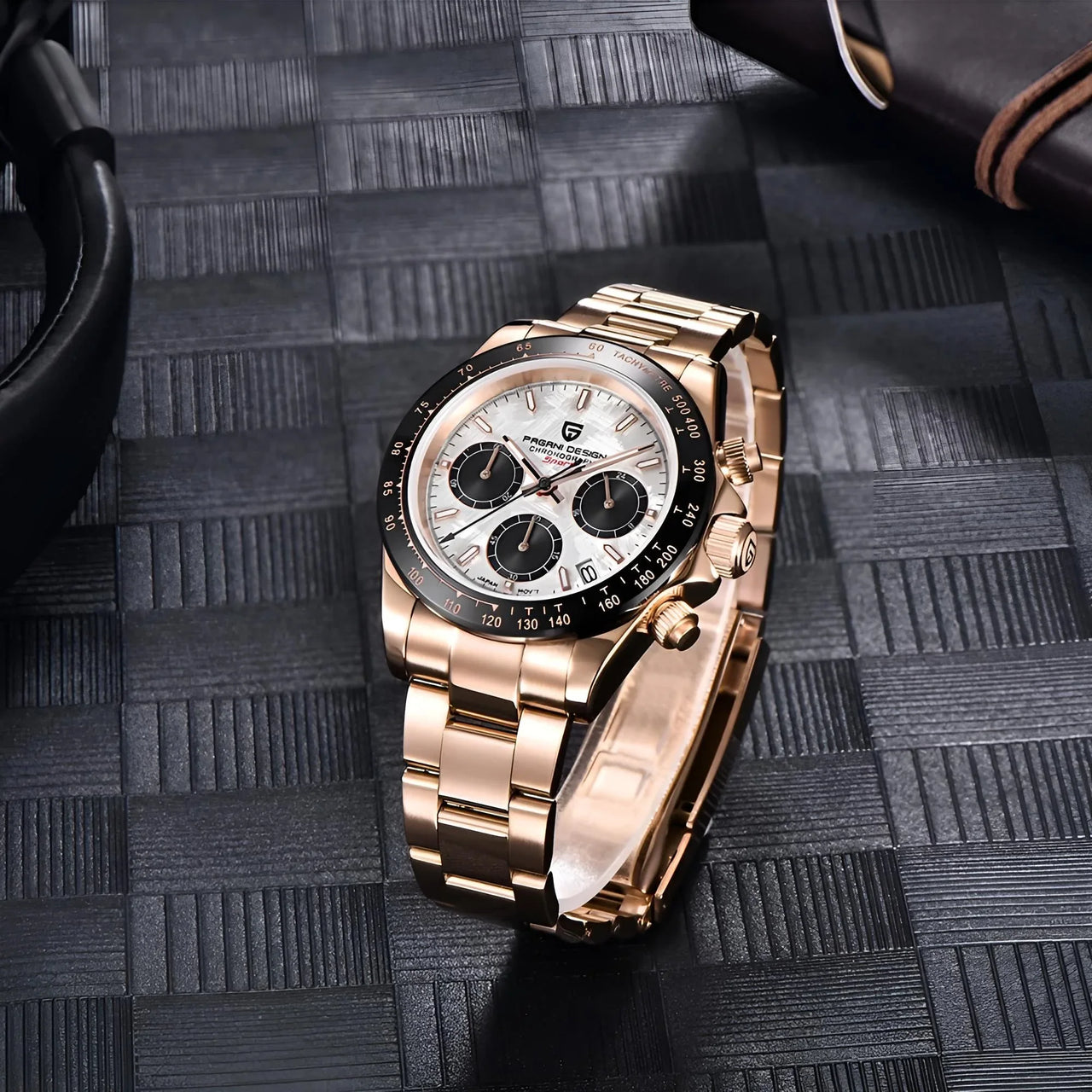 Men's luxury gold watch with a detailed face on a textured black surface