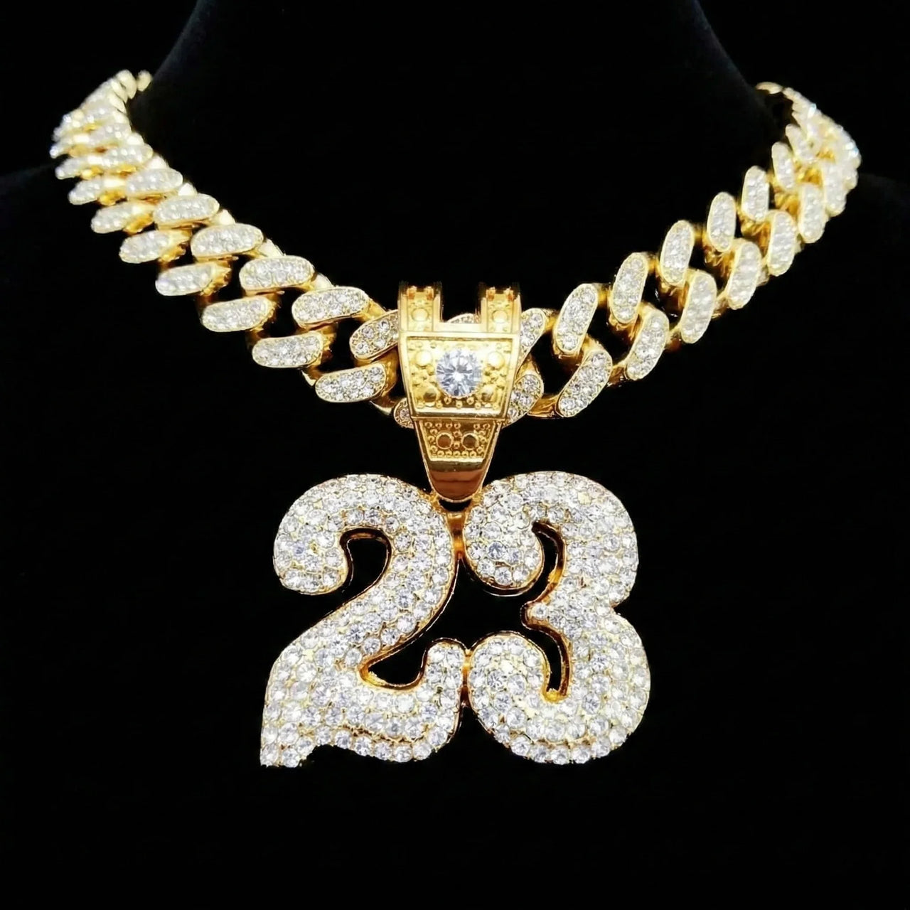 Gold necklace with a '23' pendant on a black background