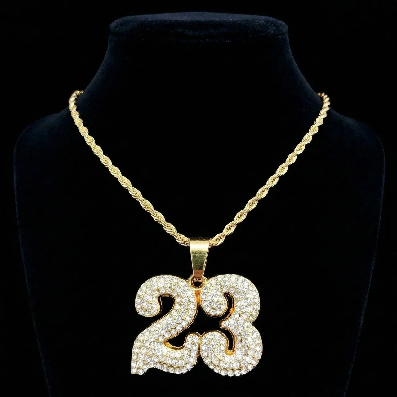 Gold necklace with a '23' pendant on a black background