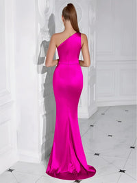 Thumbnail for Back view of a woman wearing a fuchsia one-shoulder draped maxi dress in a white room.