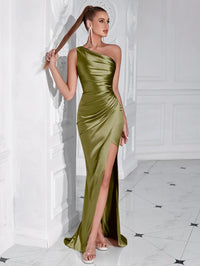 Thumbnail for Woman wearing an olive green one-shoulder draped maxi dress with a high slit in a white room.