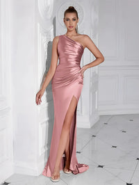 Thumbnail for Woman wearing a pink one-shoulder draped maxi dress with a high slit in a white room.