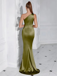 Thumbnail for Back view of a woman wearing an olive green one-shoulder draped maxi dress in a white-walled room.