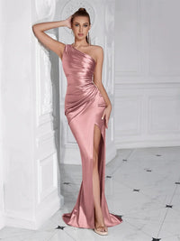 Thumbnail for Woman wearing a pink satin one-shoulder draped maxi dress with a high slit in a white room.