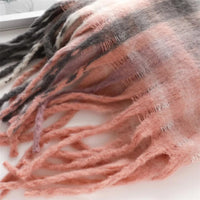Thumbnail for Close-up of a pink and gray striped scarf with tassels on a white background