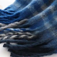 Thumbnail for Close-up of a blue and gray plaid scarf with frayed edges.
