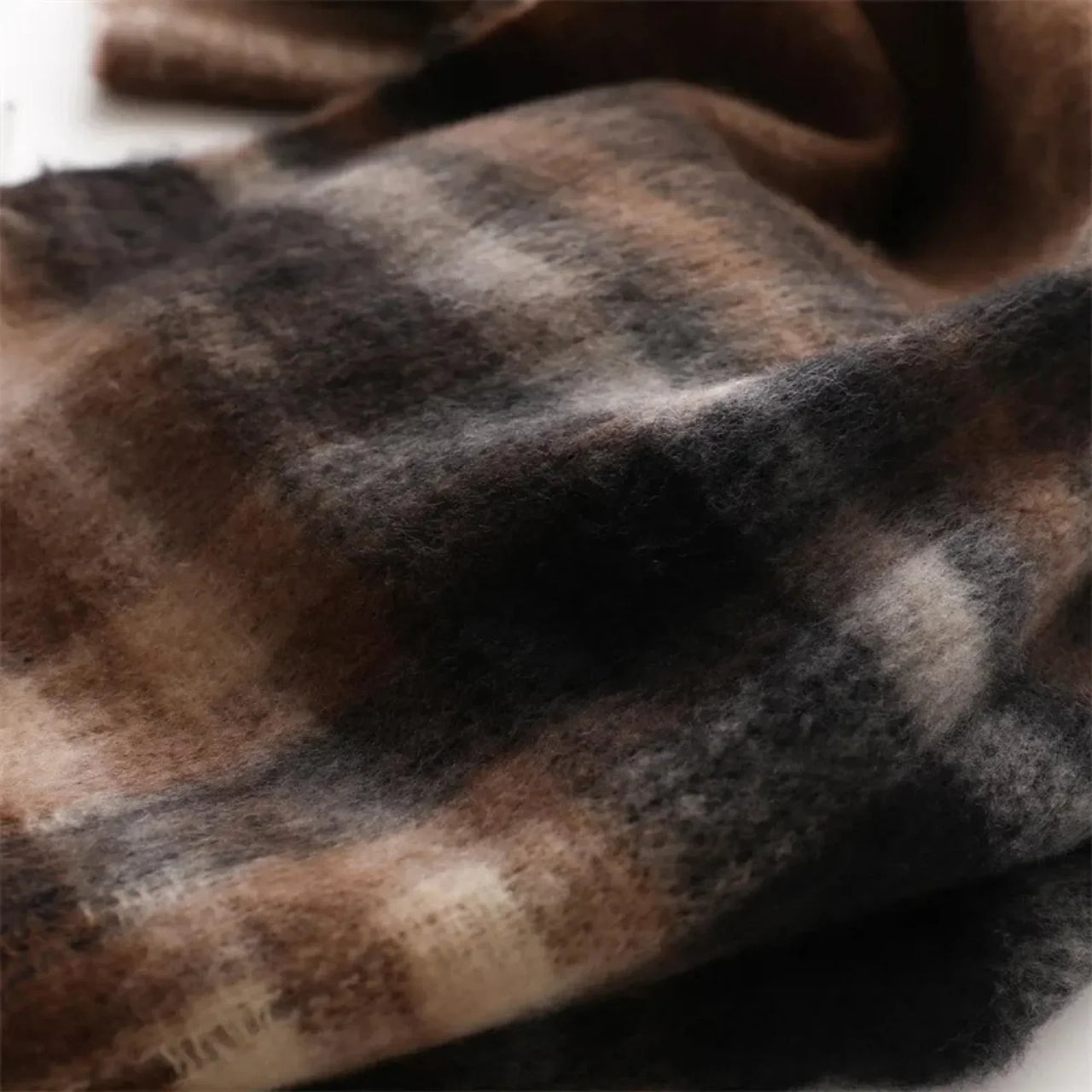 Close-up of a plaid scarf with brown, black, and beige colors.