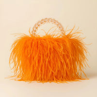 Thumbnail for Orange ostrich feather handbag with a decorative handle on a beige background