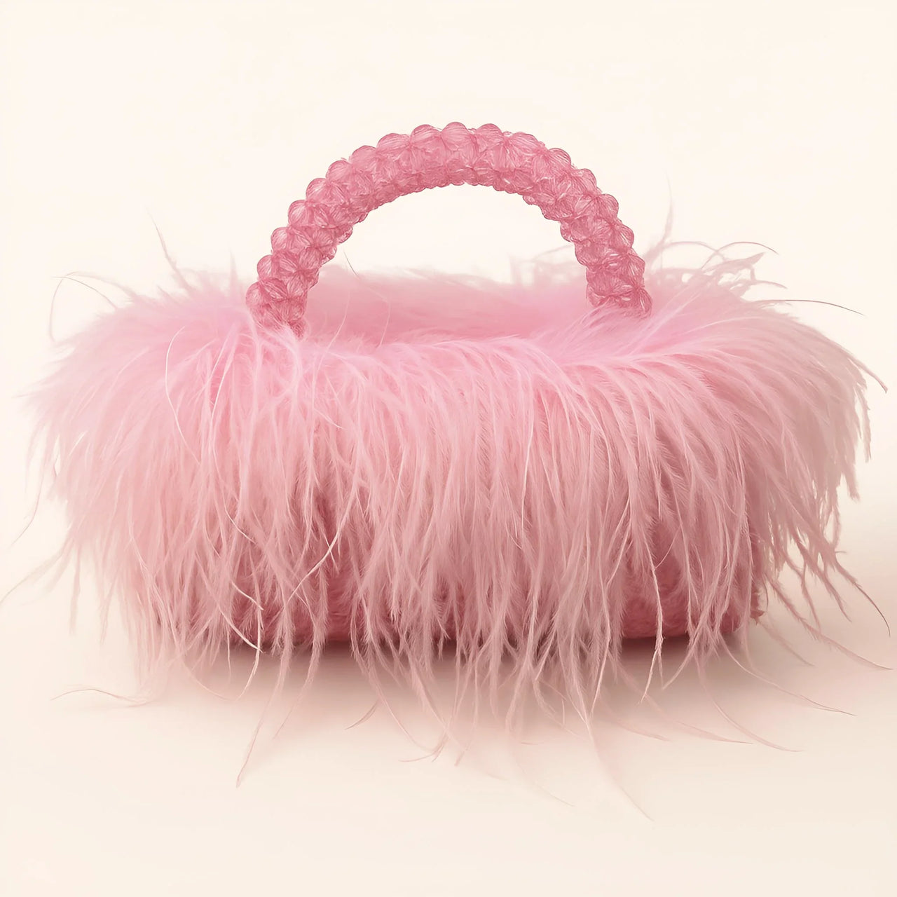 Pink ostrich feather handbag with decorative handle on a white background