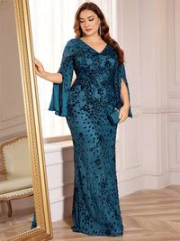 Thumbnail for Woman wearing a plus size teal evening gown with floral patterns in an elegant room.