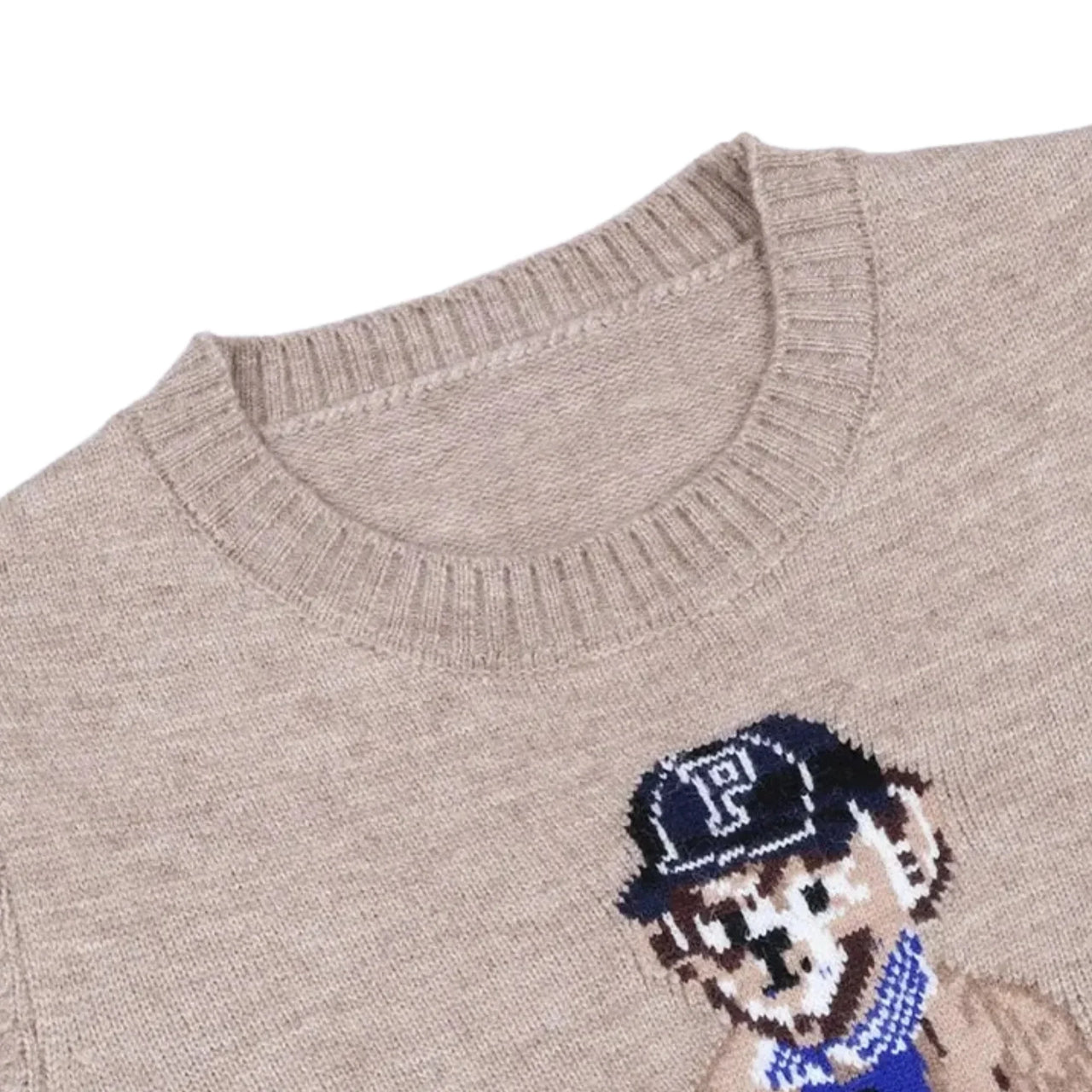 Close-up of a khaki pullover sweater with a teddy bear design on a white background