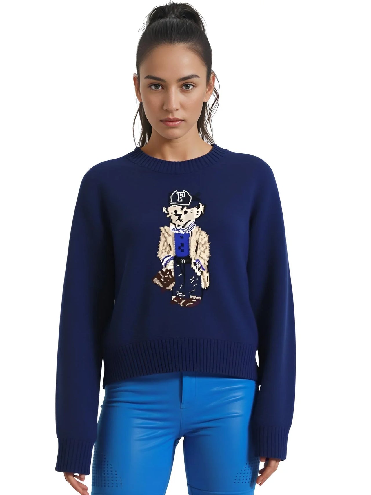 Woman wearing a navy blue sweater with a teddy bear on the front on a white background