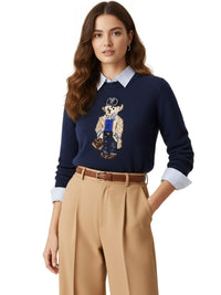 Thumbnail for Woman wearing a navy pullover sweater with a teddy bear design, beige pants, and a belt on a white background