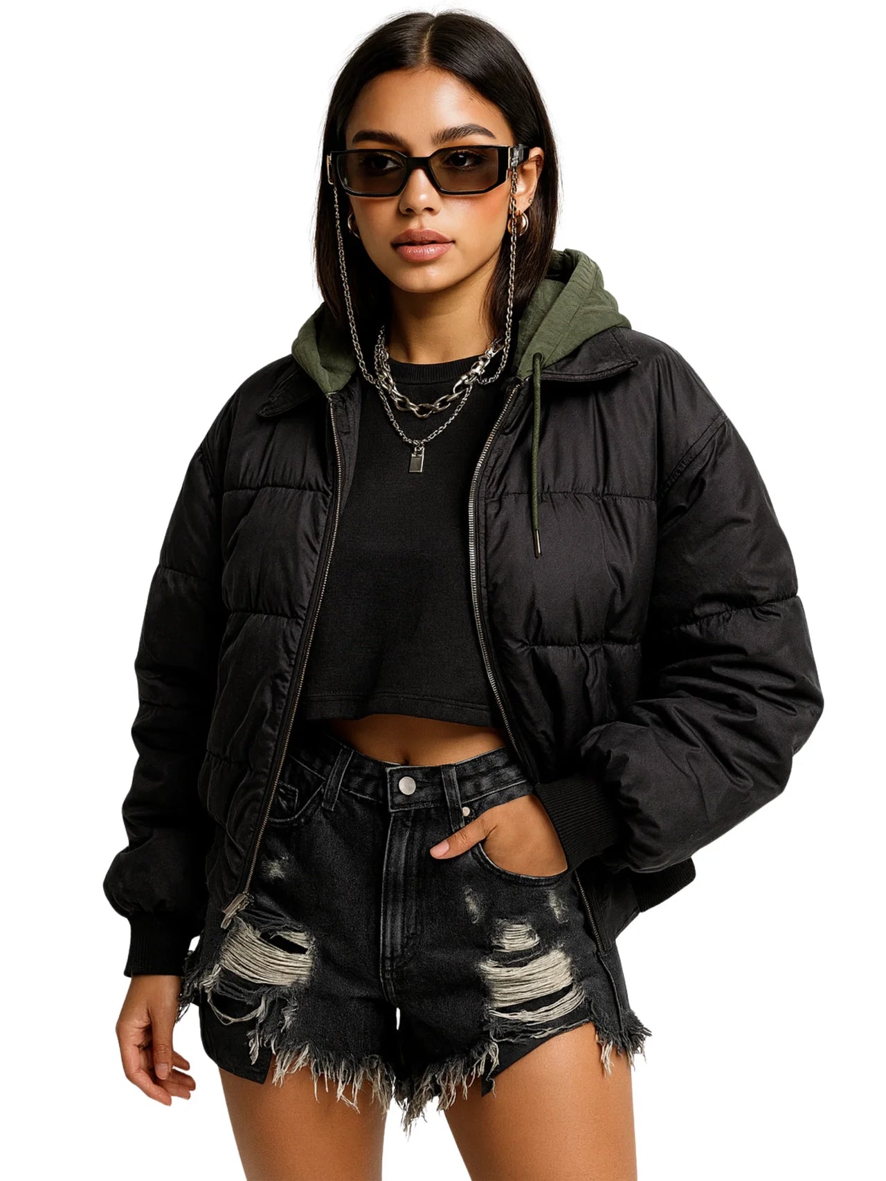 Woman wearing a black puffer jacket, black crop top, and distressed black denim shorts on a white background