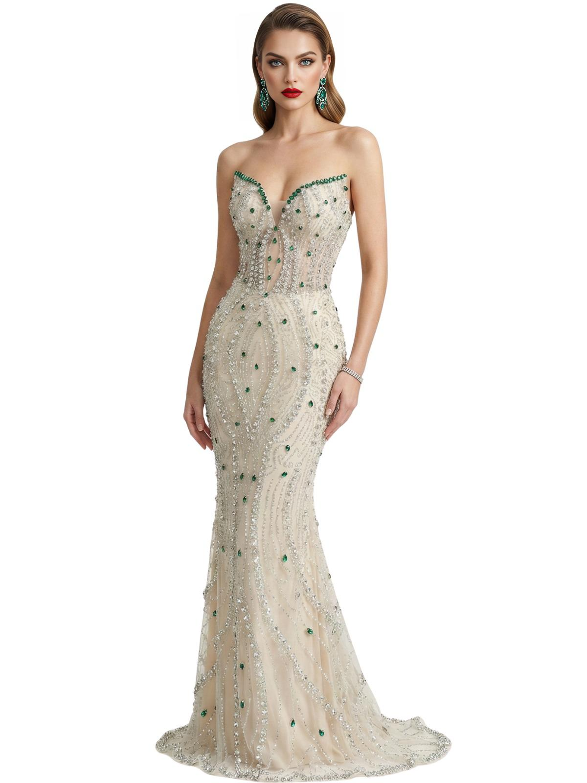 Woman wearing a strapless, beaded mermaid evening gown with green gem stones on a white background