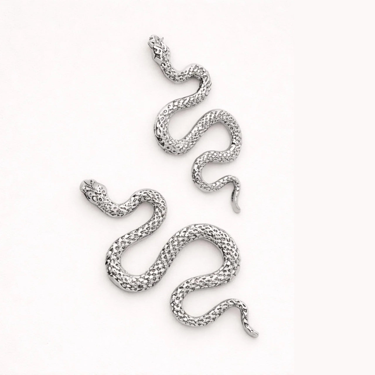 Silver snake earrings on a white background