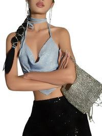 Thumbnail for Woman wearing a sparkly blue halter top and black pants with a matching bag on a white background