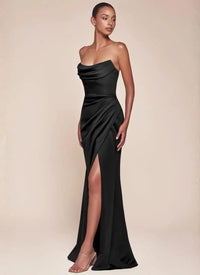 Thumbnail for Woman wearing a black strapless evening gown with a high split on a beige background