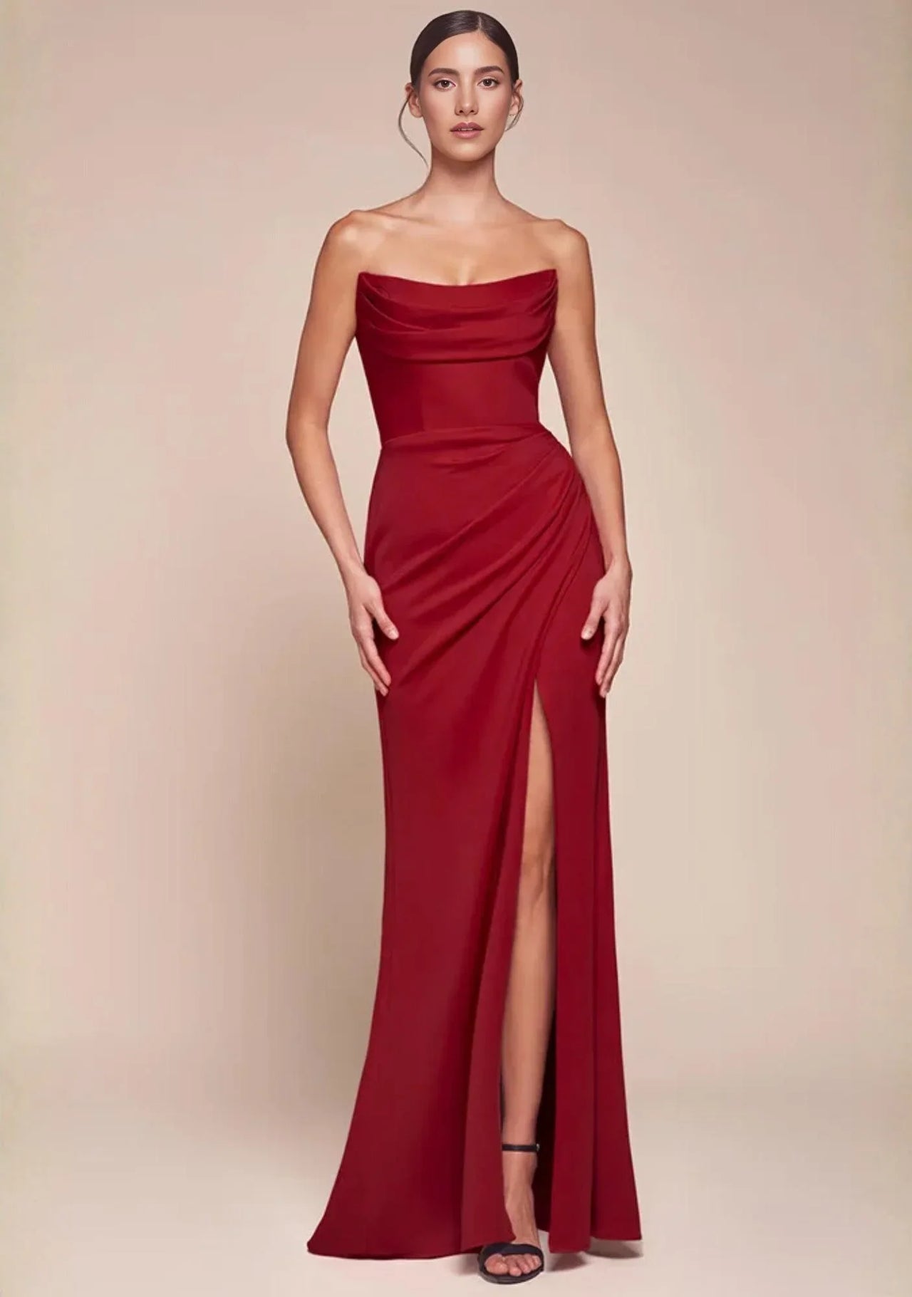Red strapless evening gown with a high split on a beige background