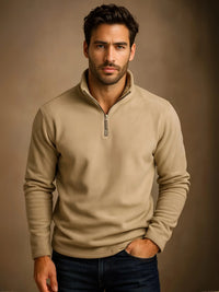 Thumbnail for Man wearing a beige half-zip sweater against a brown background