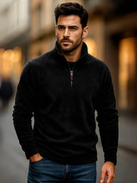 Thumbnail for Man wearing a black quarter-zip sweater with a blurred background