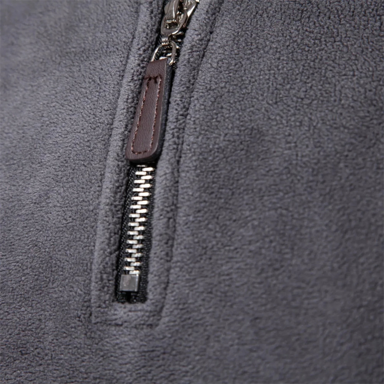 Close-up of a gray fleece sweater with a zipper detail
