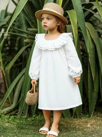 Thumbnail for Young girl in a white dress and straw hat standing in front of green plants