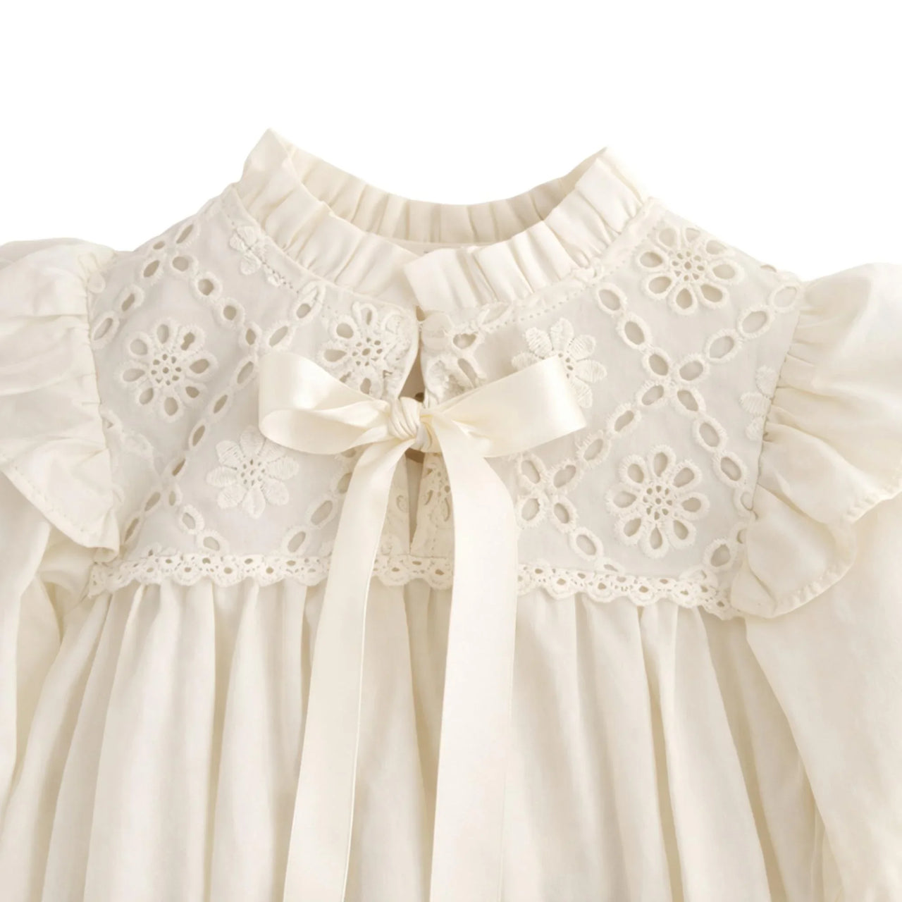 Antique white baby romper with floral lace details and bow accent on a white background